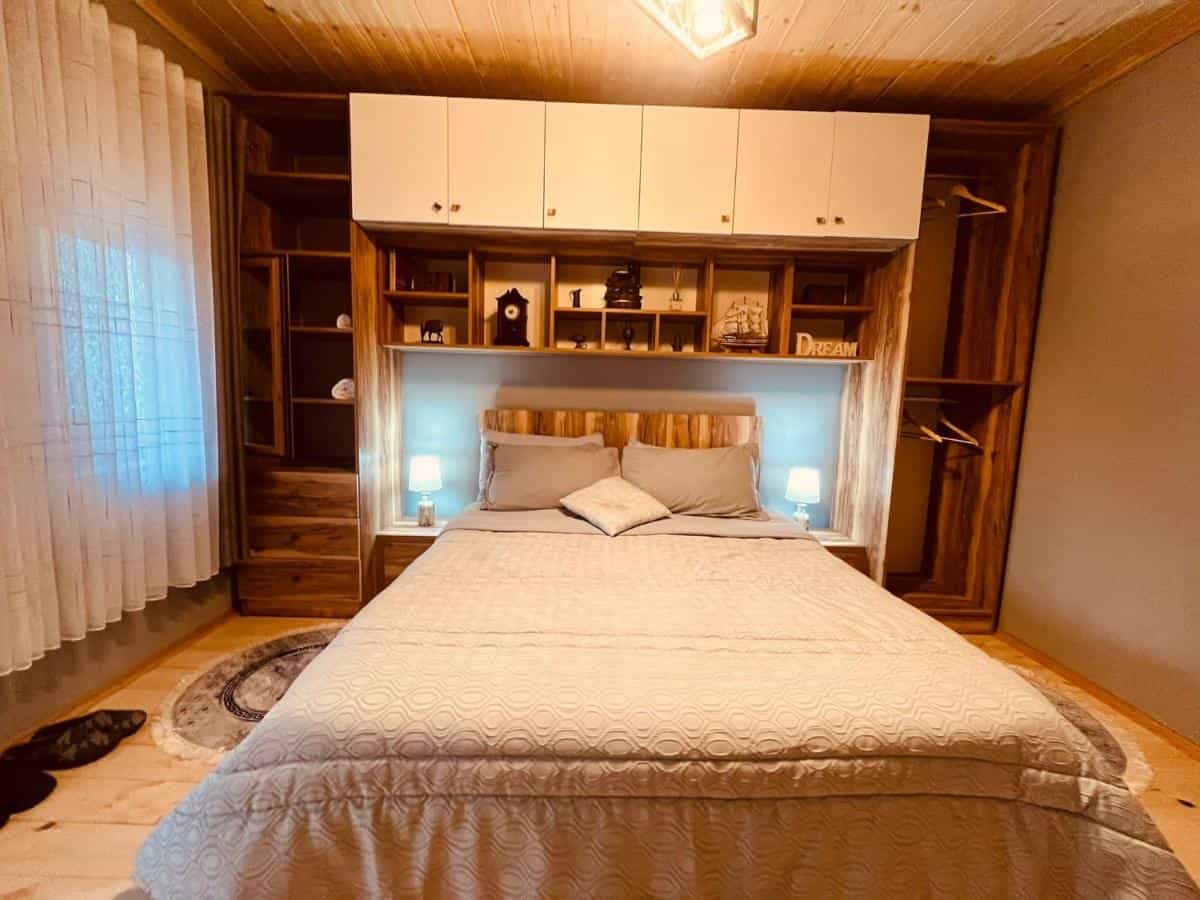 Cozy bedroom with wooden accents, built-in shelving, and a large bed in Guesthouse Gjin Thana.