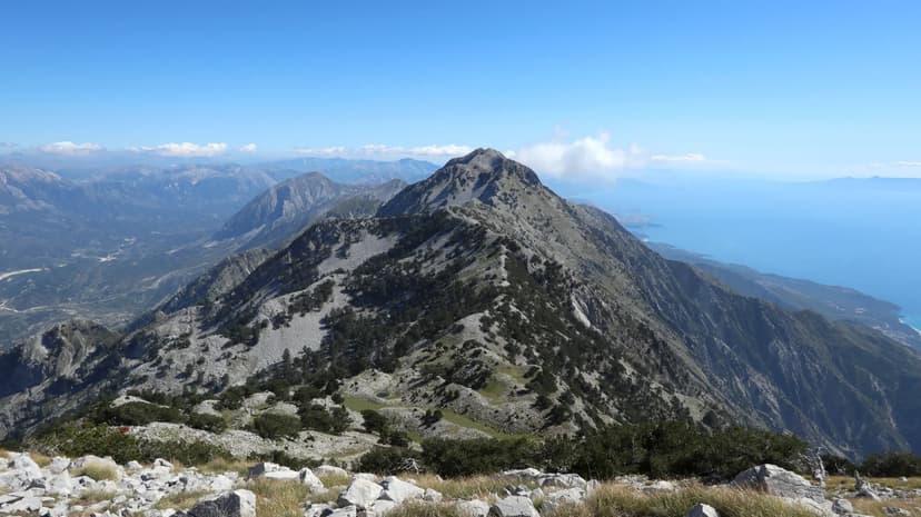 Maja Qores peak towering over rugged mountain landscape and sea view