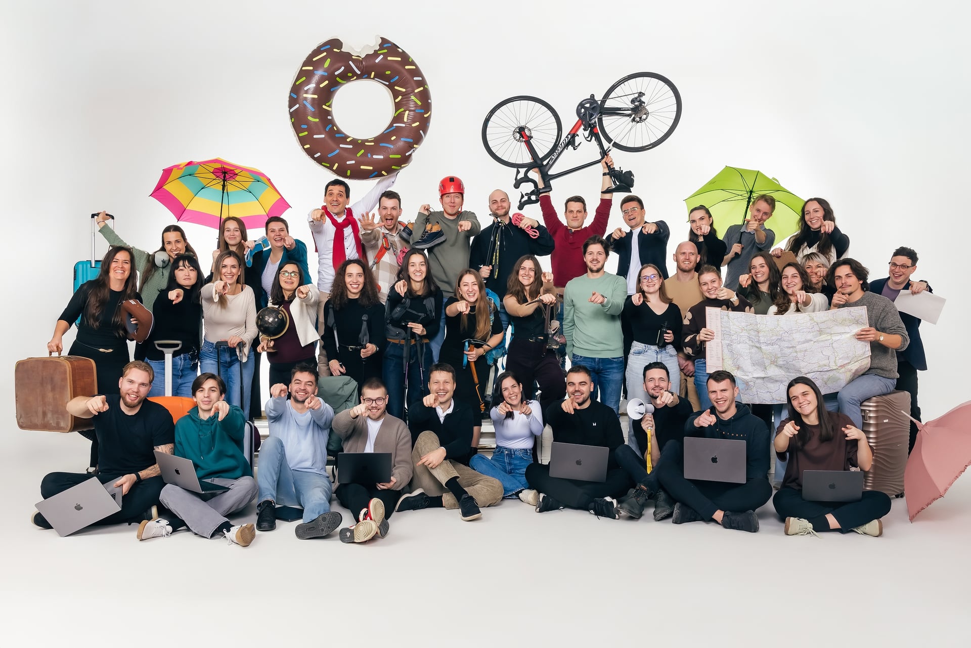 The whole World Discovery team in a studio group photo with travel props