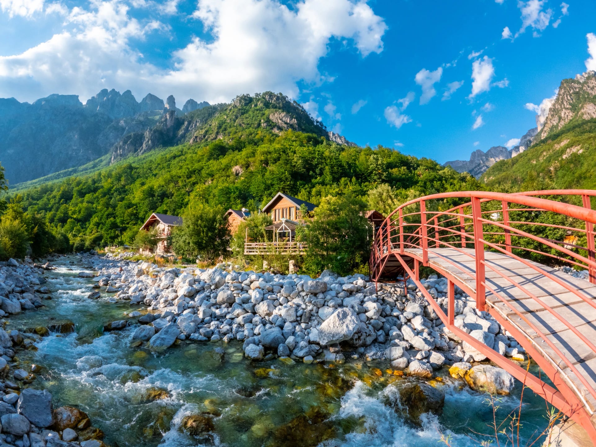 A red footbridge over the Valbona river