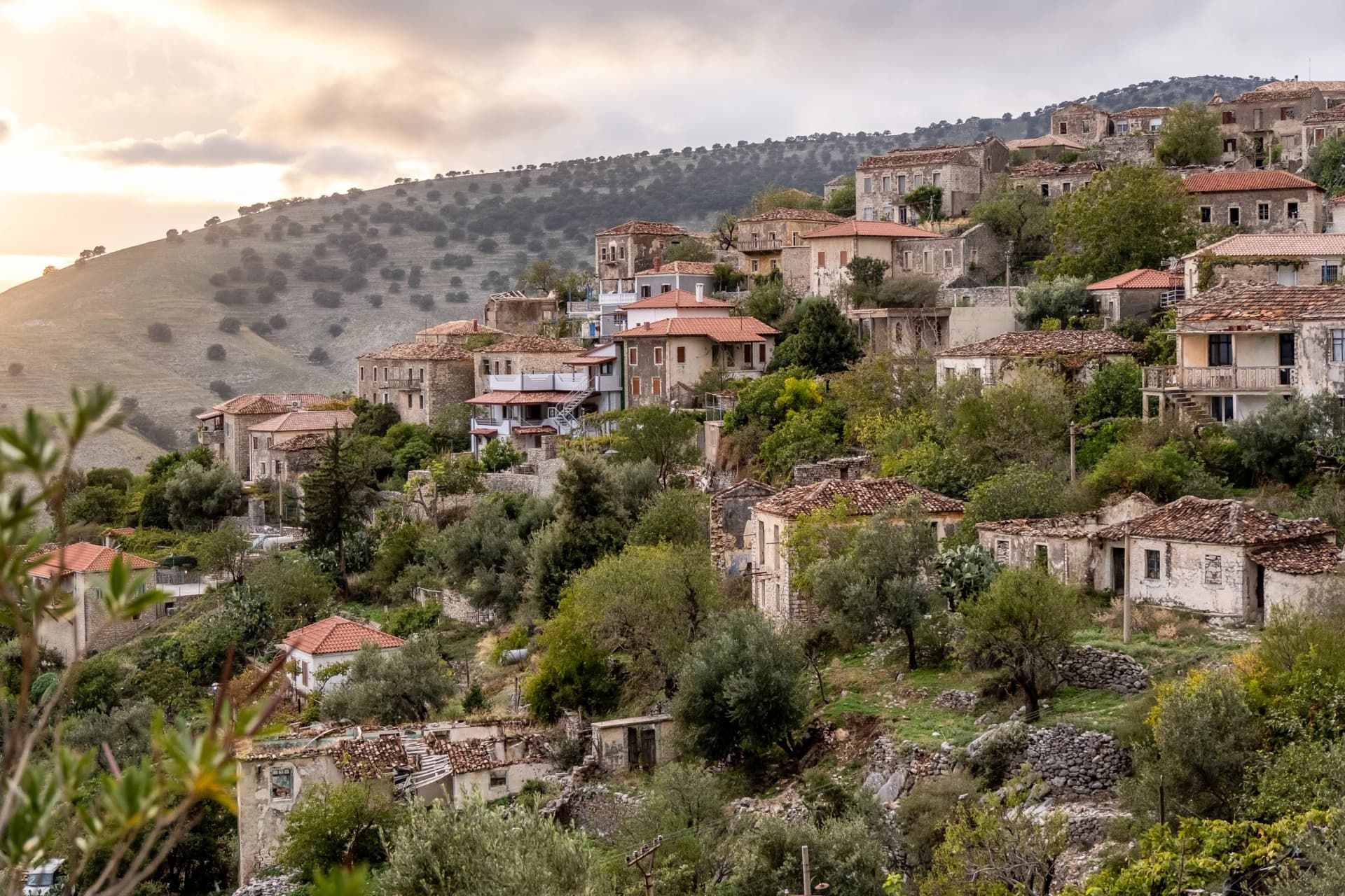 Sonnenbeleuchtete Dorfansicht alter Steinbauten am Hang, Qeparo, Qark Vlora, Albanien
