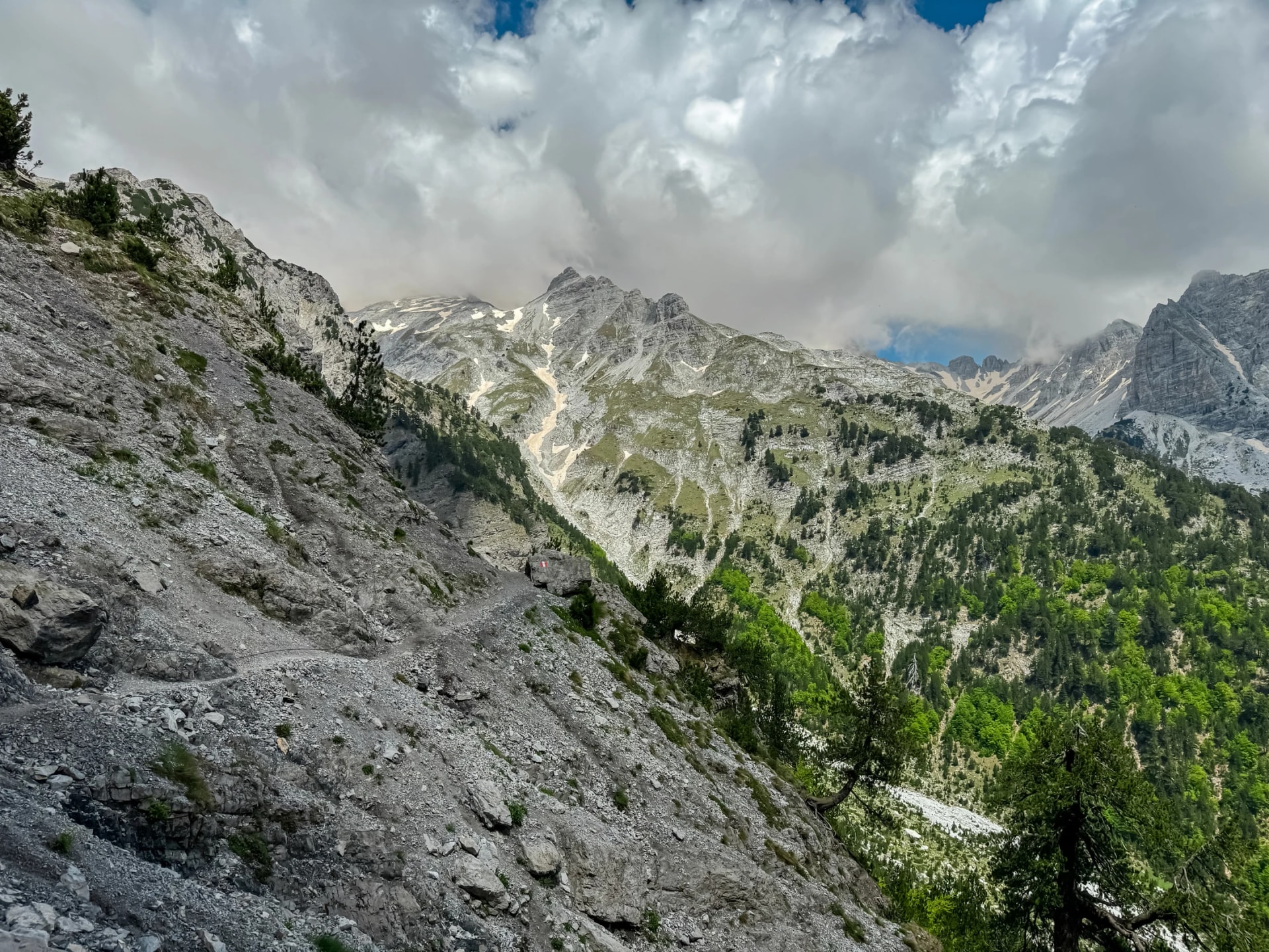 Scenic hiking trail surrounded by majestic steep mountain ridges of Albanian Alps (Accursed Mountains). Crossing high altitude pass between Valbone Valley and Thethi National Park, Albania. Wanderlust