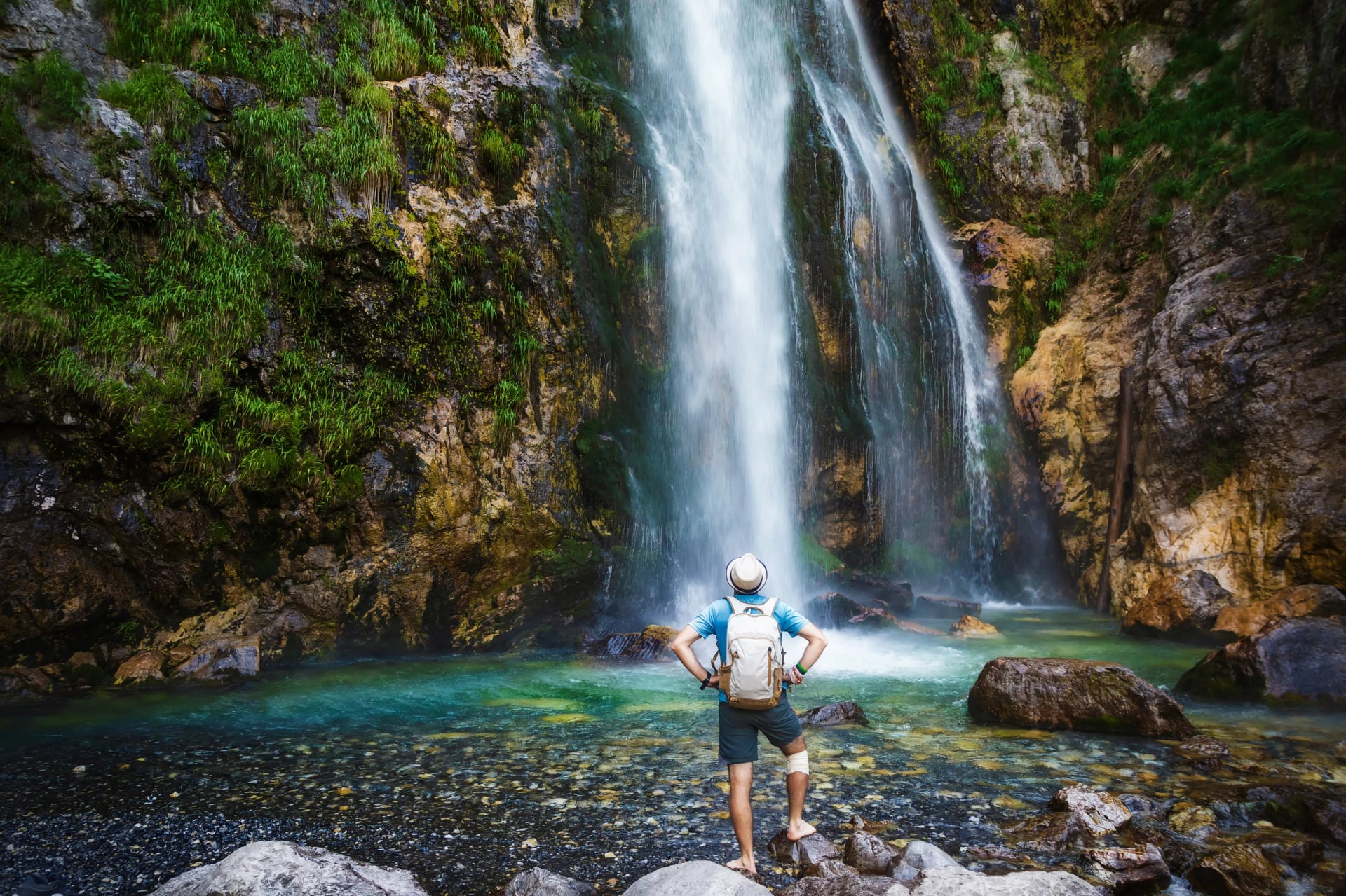 A hiker under Grunas waterfall